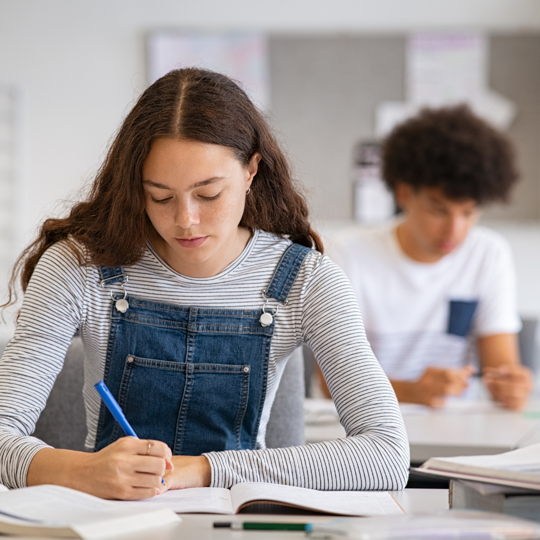 Adults writing at tables in a classroom