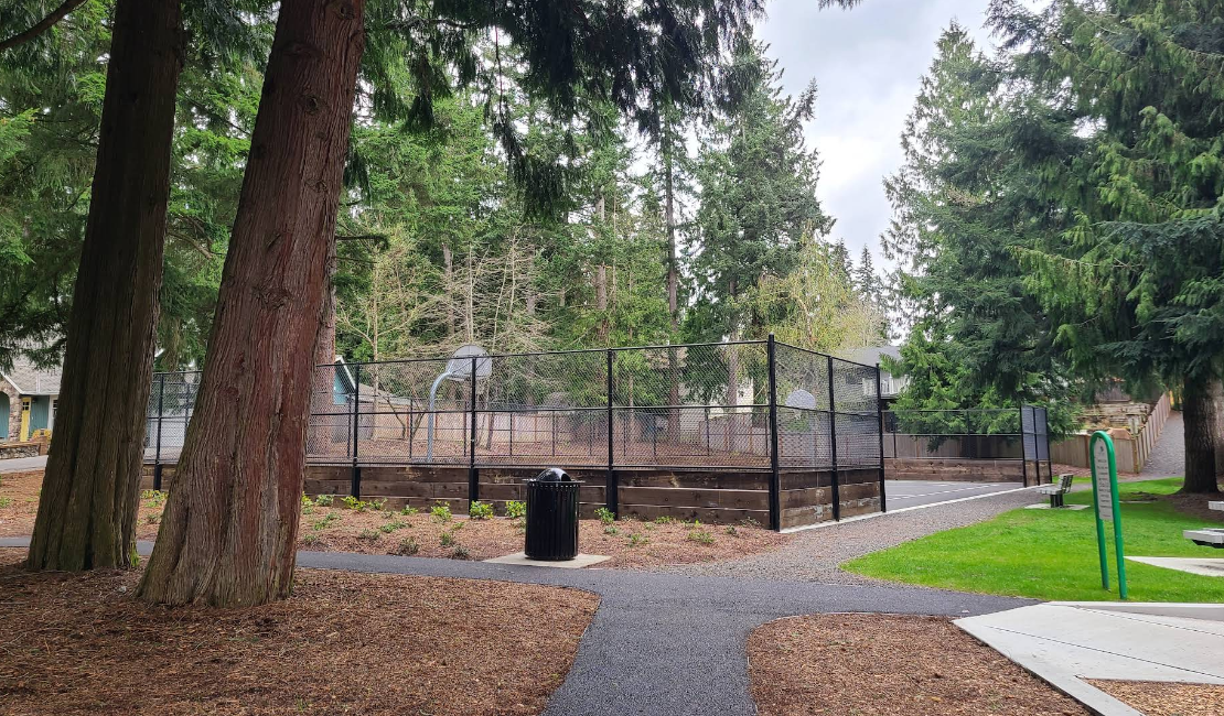 Silver Crest Park Post Construction, showing a basketball court, a path, and a garbage can.