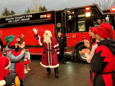 Santa waves to the crowd as he exits his South County Fire sleigh!