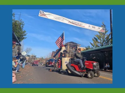 Mill Creek Veterans Day Parade featuring a small helicopter pulled by a tractor.