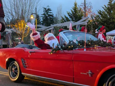 Holidays on Main featuring Santa arriving to the Tree Lighting Ceremony in a red classic car.
